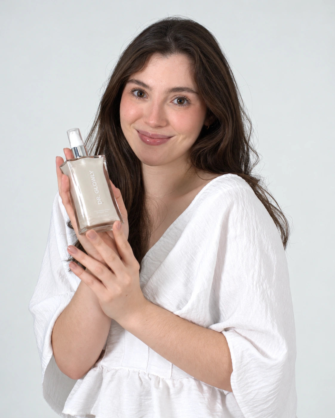 Modelo sosteniendo el shimmer de tono blanco perla Dr. Glowly.